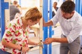 Teacher With Student In Carpentry Class Fitting Door Lock