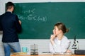 Teacher and student near chalkboard. College university education. High school. Solving task. Man writing on chalkboard