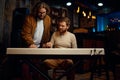 Teacher and student playing synthesizer during lesson