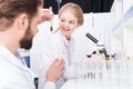 Teacher and student scientists examining green plant with soil in test tube Royalty Free Stock Photo
