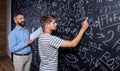 Teacher and student writing on big blackboard with mathematical Royalty Free Stock Photo