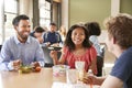 Teacher And Students Eating Lunch In High School Cafeteria During Recess