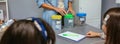 Teacher and students in an ecology classroom learning to recycle by sorting waste