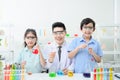 Teacher and students are looking at the camera while doing science experiments