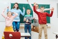 Teacher and students of primary school jumping in classroom Royalty Free Stock Photo