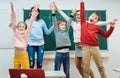 Teacher and students of primary school jumping in classroom Royalty Free Stock Photo