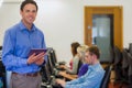 Teacher with students using computers in computer room Royalty Free Stock Photo