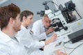 Teacher with students using microscope in science class Royalty Free Stock Photo