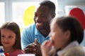 Teacher Supervising Children Eating School Lunch