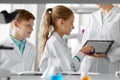 Teacher with tablet pc and kids at chemistry class