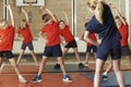 Teacher Taking Exercise Class In School Gym