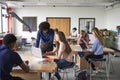 Teacher Talking To Female High School Student Sitting At Work Bench Using Laptop In Design And Technology Lesson Royalty Free Stock Photo