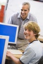 A teacher talks to a schoolboy using a computer