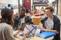 Teacher Talks To Students In Communal Area Of College Campus