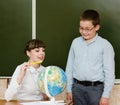 Teacher teaches boy showing Globe