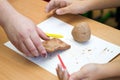 The teacher teaches the student to sculpt with clay.