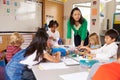 Teacher teaching elementary kids with block play in class