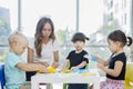 Teacher teaching her pupils to fold origamis