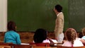 Teacher teaching math to her young pupils in classroom