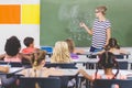 Teacher teaching mathematics to school kids in classroom