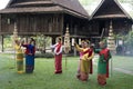 A teacher is teaching Thai dance to students in a Thai style house