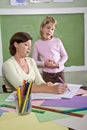 Teacher teaching young student in classroom Royalty Free Stock Photo