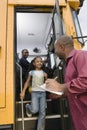 Teacher Unloading Elementary Student From School Bus Royalty Free Stock Photo