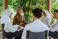 teacher uses a clipboard to teach students in the gazebo