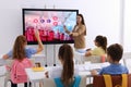 Teacher using interactive board in classroom during lesson