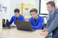 Teacher watching students use computers Royalty Free Stock Photo