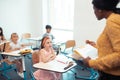 Teacher wearing yellow blouse teaching smart cute pupils