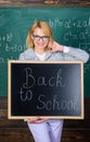 Teacher woman hold blackboard inscription back to school. It is school time again. School teacher glad to welcome pupils Royalty Free Stock Photo