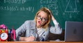 Teacher woman sit table classroom chalkboard background. Still working. Work far beyond actual school day. Teacher