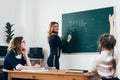 Teacher writes a mathematical example on the blackboard Royalty Free Stock Photo