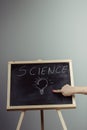 A teacher writing science, drawing chemistry elements on dark ch Royalty Free Stock Photo