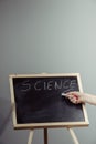 A teacher writing science, drawing chemistry elements on dark chalkboard by hand Royalty Free Stock Photo