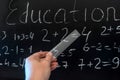 Teacher writing various primary school maths formula on chalkboard
