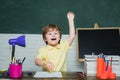 Teachers day - education for pupil in school. Cheerful smiling little pupil having fun against blackboard. Funny little