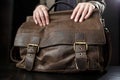 Teachers female hands hold on to an antique brown leather briefcase. Royalty Free Stock Photo