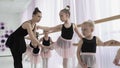 Teachers show how to dance to little ballerinas. Girl dancer in ballet school learns to dance. Young ballerinas jumping Royalty Free Stock Photo