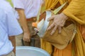 Teachers and students together make merit to give food offerings to a Buddhist monk on important religious days