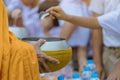 Teachers and students together make merit to give food offerings to a Buddhist monk