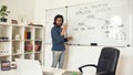 Teaching code programming. Young bearded male teacher pointing at whiteboard and explaining how to code HTML CSS, giving