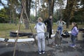 Teaching of forging. Boy pumping air to a forge using bellows, little girl and a man watching