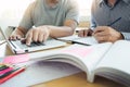 Teaching helping technology concept. Woman young teacher or tutor with adult students in classroom at desk with papers, laptop co