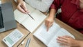 Teaching helping technology concept. Woman young teacher or tutor with adult students in classroom at desk with papers, laptop