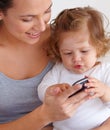 Teaching her the ways of a cellphone. A baby girl staring in fascination at her mothers cellphone. Royalty Free Stock Photo