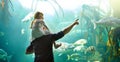 Teaching his little girl all about the sea. a father and his little daughter looking at an exhibit in an aquarium. Royalty Free Stock Photo