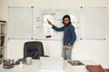 Teaching Java Language online. Professional male teacher standing near whiteboard and giving Javascript lesson online