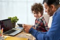 Teaching kid. Portrait of cute little hispanic school boy doing homework together with his father, using technology Royalty Free Stock Photo